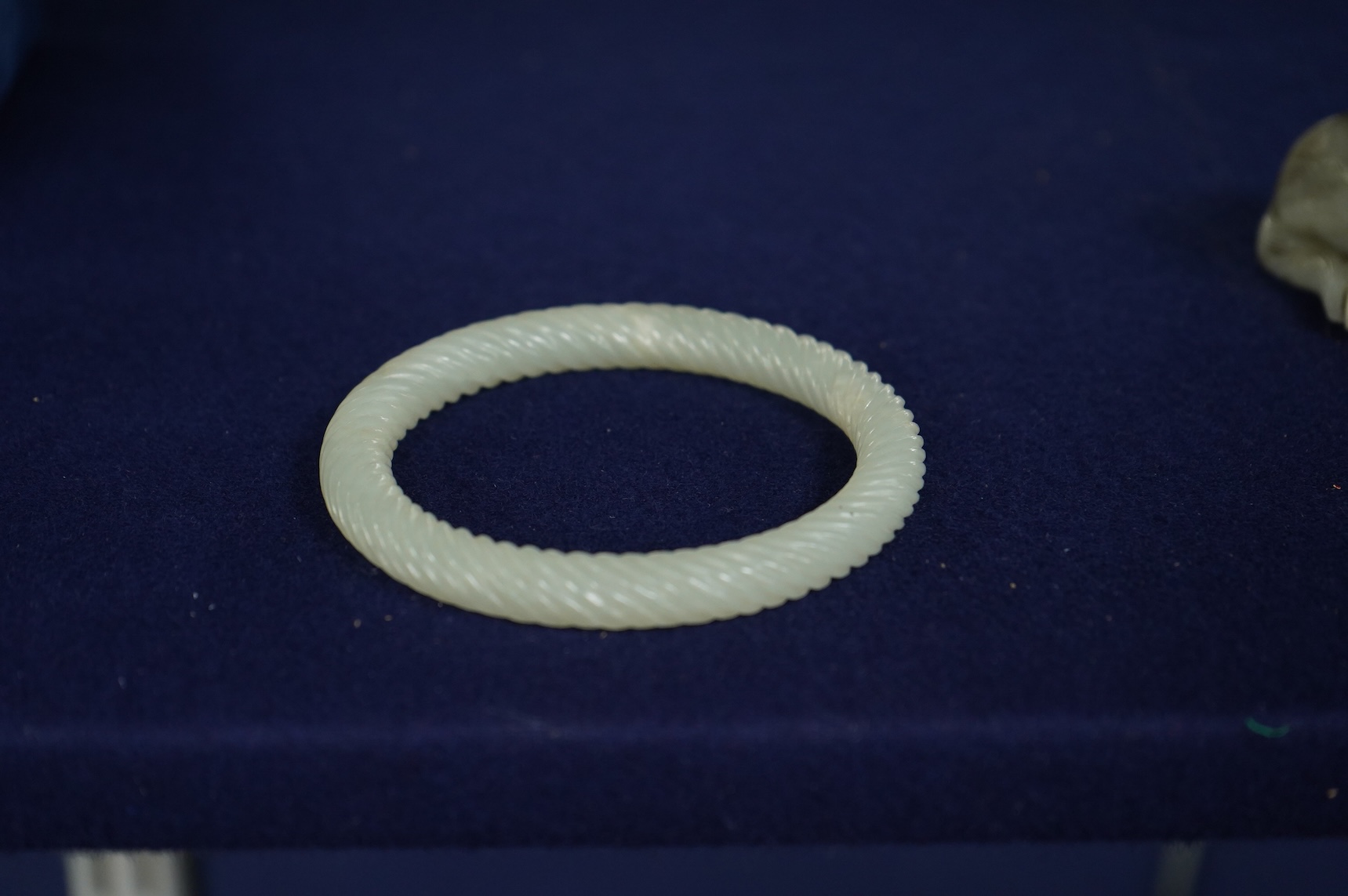 A Chinese pale celadon jade rope twist carved bangle, 8cm diameter